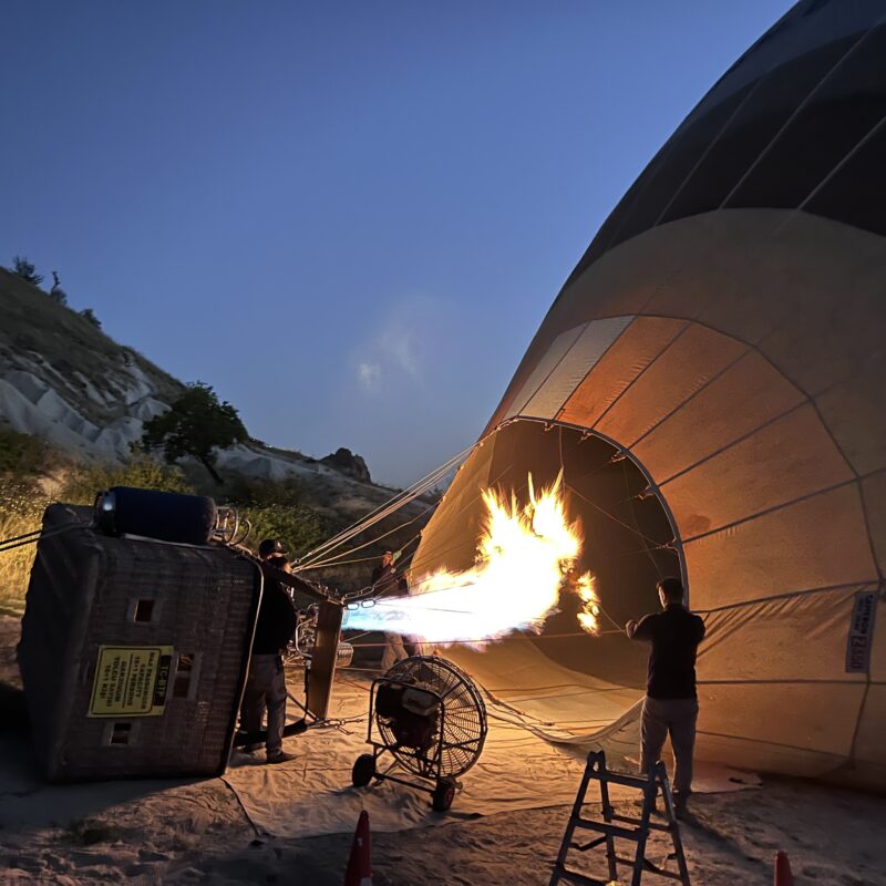 inflating a hot air balloon which is lying on its side in cappadocia, turkey